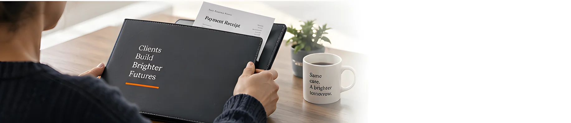 A bookkeeper closes a folder holding a printed payment receipt beside a mug on a wooden desk