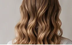 Long wavy hair with soft blonde balayage, seen from behind