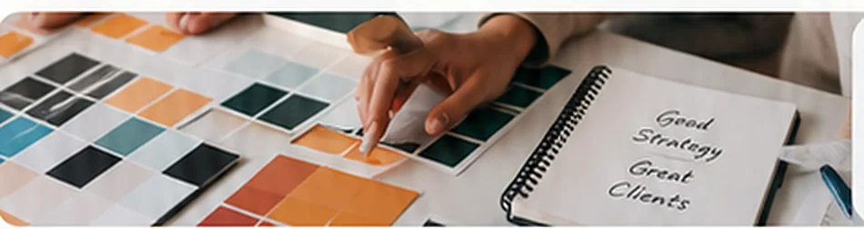 Hands sorting color proof sheets beside a notebook